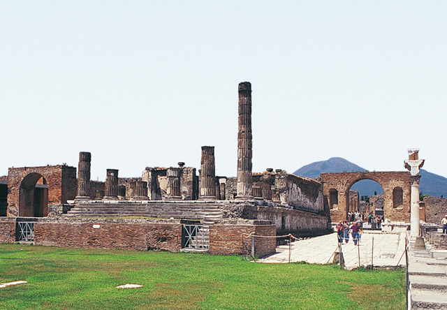 The majestic architecture of the Temple of Jupiter which stands out against the impressive outline of Mount Vesuvius